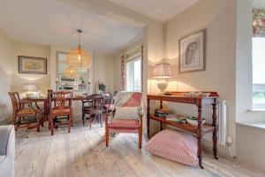 a living room and dining room with a table and chairs at No 1 Sparham Hall - Norfolk Cottage Agency in Necton