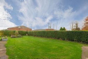 a large yard with green grass and a hedge at No 1 Sparham Hall - Norfolk Cottage Agency in Necton