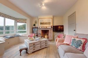 a living room with a couch and a fireplace at No 1 Sparham Hall - Norfolk Cottage Agency in Necton