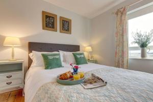 a tray of food on a bed in a bedroom at No 1 Sparham Hall - Norfolk Cottage Agency in Necton