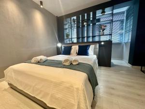 a bedroom with a large bed with towels on it at Luxury by Magic Apartments in Bucharest