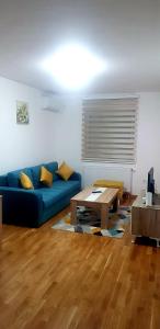 un salon avec un canapé bleu et une table dans l'établissement Stan na dan CENTAR 7, à Doboj