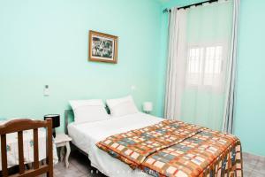a blue bedroom with a bed and a window at Odza, modern apartment, 3 bedrooms, private parking in Yaoundé
