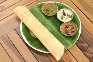 a green plate of food on a banana leaf at Hotel Holiday Comfort - 800 mts from Jallianwala Bagh in Amritsar +60 photos