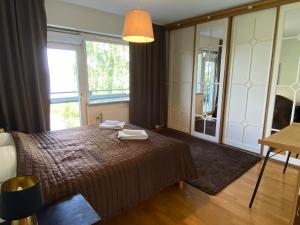 a bedroom with a bed and a large window at Kolme makuuhuonetta Merenrannalla Lauttasaaressa in Helsinki