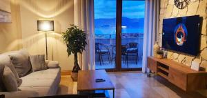 a living room with a couch and a tv and a table at Villa Salena with pool Slatine in Slatine