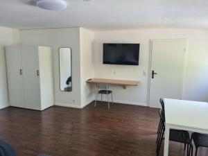 a room with white walls and a table and two mirrors at Pension An der Mühle in Sottrum