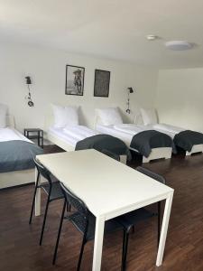 a room with four beds and a table and chairs at Pension An der Mühle in Sottrum