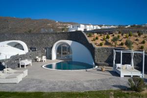 Danae Suites Santorini في أويا: فناء به مسبح و منزل