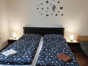 ein Schlafzimmer mit 2 Betten und einem Dekolleté an der Schmetterlingswand in der Unterkunft Apartmán pri starom dube in Veľký Meder
