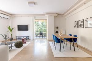 sala de estar con mesa y sillas azules en Captivating 2BR Apartment in Chalandri by UPSTREET, en Atenas