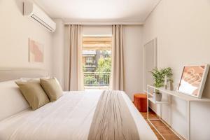 a white bedroom with a large bed and a window at Captivating 2BR Apartment in Chalandri by UPSTREET in Athens