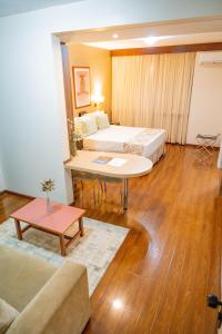 a hotel room with two beds and a couch at Black Stream Hotel in Ribeirão Preto