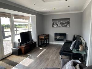 a living room with a couch and a television at The Bungalow in Preston