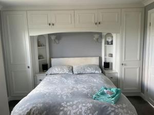 a bedroom with a large bed with white cabinets at The Bungalow in Preston