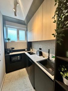 a kitchen with wooden cabinets and a sink at Luxury by Magic Apartments in Bucharest