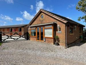 a brick house with a gate and a gravel driveway at The Bungalow in Preston