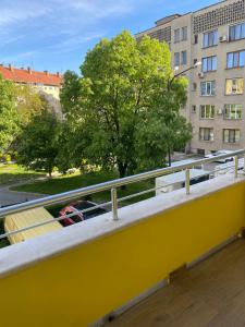 a yellow balcony with a view of a city at Апартамент за гости ДИГЕНА in Kazanlŭk