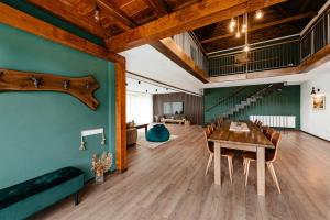 a dining room with a table and a green wall at Green Forest Ghermin in Negreni