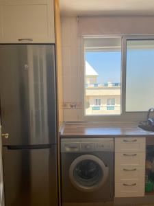a kitchen with a refrigerator and a washing machine at Piso primera línea, Banana Beach, Marbella. in Marbella