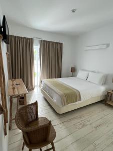 梅里戴斯的住宿－À Espera - Turismo Rural,Melides，一间卧室配有一张大床和一把椅子