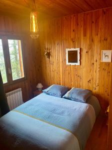 a bedroom with a bed in a wooden wall at Le refuge, chalet au pied des pistes au Sauze in Enchastrayes