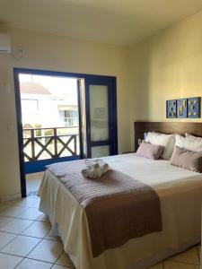 a bedroom with a large bed and a balcony at Pousada Maré Mar in Garopaba
