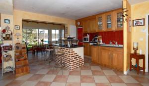 una cocina con armarios de madera y una mesa. en maison piscine, en Dompierre-sur-Mer