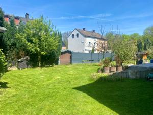 een tuin met een huis en een groen gazon bij Süßes Gästehäuschen in 1A Lage in Bochum