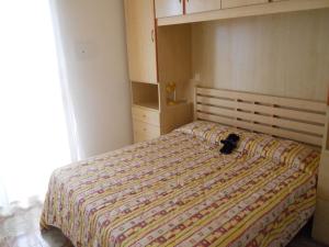 un gato acostado en una cama en un dormitorio en Flat with terrace near the beach - Beahost, en Bibione
