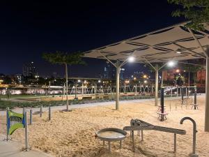 a group of tables and benches under a pavilion at night at Lovely New Central Apartment in Beer Sheva