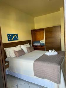 um quarto com uma cama grande num quarto em Pousada Maré Mar em Garopaba