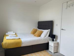 1 dormitorio con 1 cama con sábanas blancas y almohadas amarillas en City Centre, Sleeps 7, Stunning Views & Parking, Interconnected Rooms LONG STAY WORK CONTRACTOR LEISURE, DIAMOND PENTHOUSE, en Chesterton