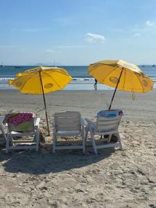 Pousada Maré Mar في غاروبابا: كرسيين ومظلتين على الشاطئ