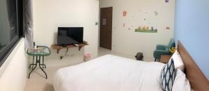 um quarto com uma cama e uma televisão de ecrã plano em Bear Baby Homestay em Jinning