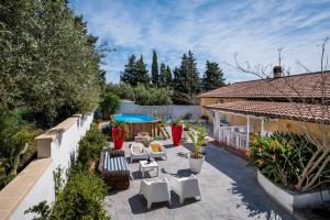 a backyard with white chairs and a patio at Villa Gagliardetta in Castellammare del Golfo