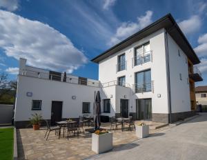a white house with a patio and tables and chairs at VULCANO Guesthouse in Vinica