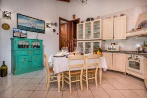 a kitchen with a table and a green cabinet at Villa Gagliardetta in Castellammare del Golfo