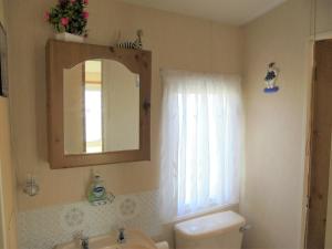 a bathroom with a sink and a mirror and a toilet at 6 Berth central heated on The Chase (Brentmere) in Ingoldmells +21 photos