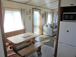 a small living room with a table and a refrigerator at 6 Berth central heated on The Chase (Brentmere) in Ingoldmells