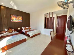 a hotel room with two beds and a tv at Hoàng Ngân Hotel Phú Yên in Liên Trì (3)