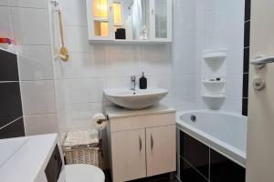 札格雷布的住宿－Apartman Mima，浴室配有盥洗盆、卫生间和浴缸。