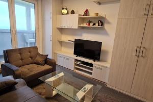 a living room with a couch and a flat screen tv at Apartman Mima in Zagreb