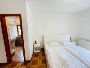 a bedroom with a white bed and a mirror at Golden Bridge Deluxe Home - 4BR, terrace, bar, privat pool, grill, pet friendly in Balatonfüred
