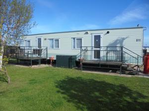 a large white house with a porch and a yard at 6 Berth central heated on The Chase (Brentmere) in Ingoldmells