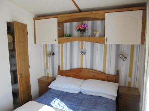 a bedroom with a bed with a wooden head board at 6 Berth central heated on The Chase (Brentmere) in Ingoldmells
