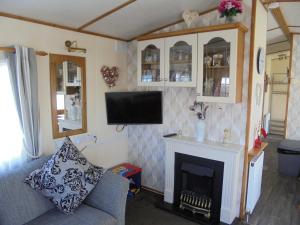 a living room with a fireplace and a tv at 6 Berth central heated on The Chase (Brentmere) in Ingoldmells