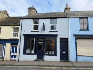 a white building with blue doors on a street at Modern 2 BR Flat in Town Centre in Aberystwyth