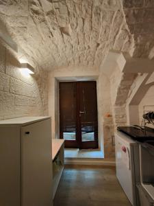 a kitchen with a stone wall and a window at La casetta di Ottavio in Castellana Grotte