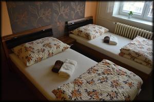 two beds with towels on them in a bedroom at Penzion U Kohoutka in Pardubice